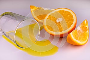 A glass with a spilled orange forefoot on a white background.