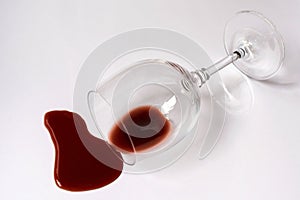 Glass with spilled red wine on a white background. Copy space.
