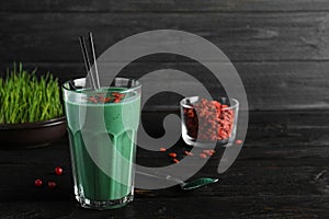 Glass of spirulina smoothie with goji berries on table