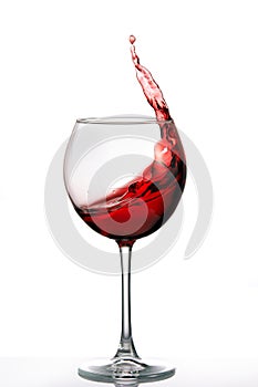 Glass with a splash of red wine isolated on white background