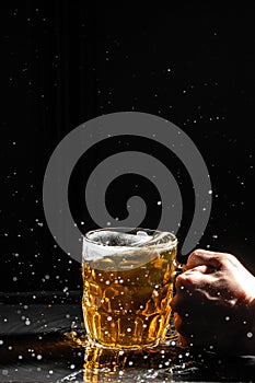 glass of splashing beer. Freeze motion splash drops of beer foam