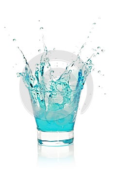 Glass with splashing blue drink