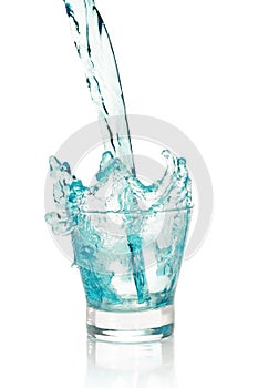 Glass with splashing blue drink