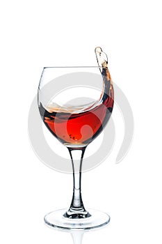 Glass with splashing red wine on white background