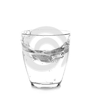 Glass with splashing water on white background