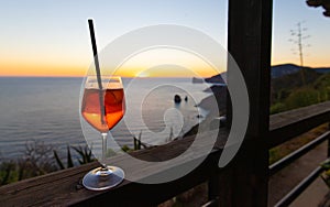 A glass of spritz in front of a beautiful sunset