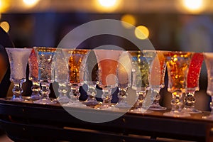 Glass stacks are filled with different drinks as an advertisement in a drinking establishment, a bar on the street