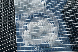 Glass and steel modern architecture pattern with reflection of cloud on the wall.   Shades of blue. Cells, geometric design.