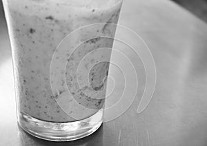 GLASS WITH STRAWBERRY MILKSHAKE ON STEEL TABLE