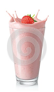 glass of strawberry smoothie or milkshake with splash and falling berry isolated on white