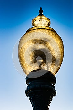 Glass street lamp head on a cast iron post