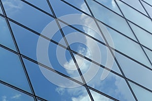 Glass surface of a building with reflection of a cloud