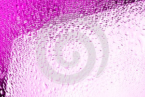 Glass surface with water drops, bright pink color, shiny drops texture, wet background, light purple gradient, close up