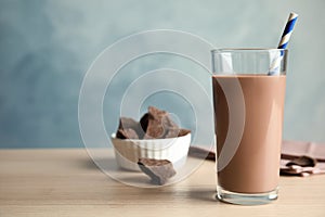 Glass of tasty chocolate milk on wooden table. Dairy drink