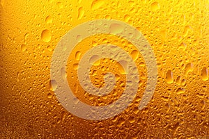 Glass of tasty cold beer with condensation drops as background, closeup
