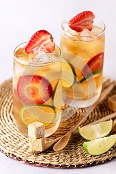 Glass of Tasty and Cold Ice Tea with Strawberry and Lime Healthy Diet and Summer Beverage Vertical