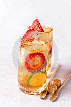 Glass of Tasty and Cold Ice Tea with Strawberry and Lime Healthy Diet and Summer Beverage Vertical