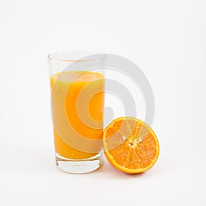 The glass of tasty pure orange juice and fresh orange half
