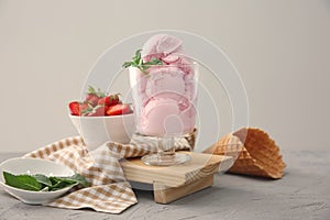 Glass with tasty strawberry ice cream on table