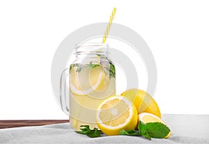 A glass with a tasty and useful cocktail from a juicy bright yellow lemon and fresh mint isolated on a white background.