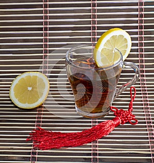 Glass of tea and nearby lemon, on a rug