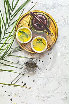 Glass tea pot, ceramic pot and green tea in strainer