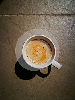 A glass of Tea (Teh Tarik) with shadow on the tile