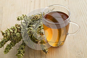 Glass of tea with twigs of dried green ironwort