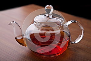 Glass teapot with black tea
