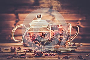 Glass teapot with blooming tea flower photo