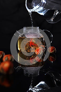 Glass teapot with blooming tea flower inside.Chinese tea with jasmine. Jasmine tea in transparent teapot. Opening of