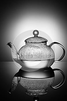 Glass teapot with boiling water and drops of condensation