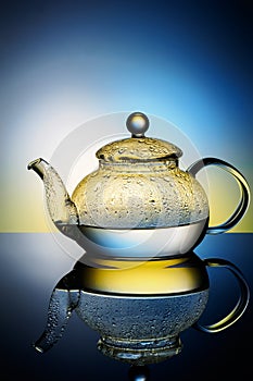 Glass teapot with boiling water and drops of condensation