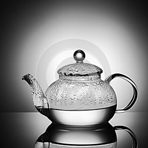 Glass teapot with boiling water and drops of condensation