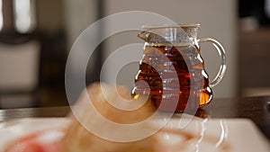 Glass teapot with freshly brewed tea, aroma of Chinese oolong tea. Traditional Chinese tea concept. Glass jug with tea