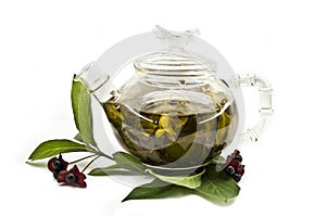 Glass teapot with green tea and tea leaves