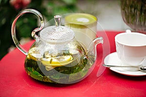 Glass teapot with mint green tea and cup