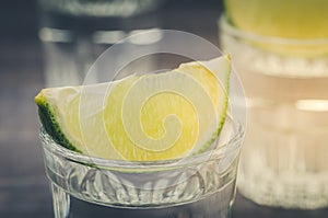 Glass of tequila with a lime/glass of tequila with a lime from above. selective focus