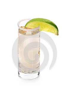 A glass with tequila, served with salt and sappy slice of lime, fervent Mexican drinks on a white background.