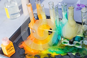 Glass test tubes with liquid in it and colorful foam in science research lab. Failed experiment concept