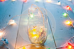 Glass and tinsel, the lights on the wooden table,