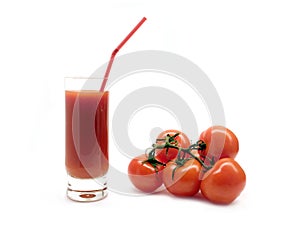 Glass with tomato juice with drink straw and ripe tomatoes studio shot isolated on white