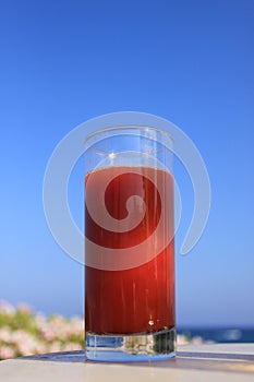 Glass of tomato juice and ocean