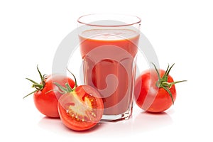 Glass with tomato juice and ripe tomatoes.