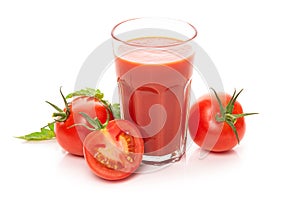 Glass with tomato juice and ripe tomatoes.