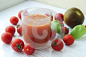 Glass of tomato juice on white background