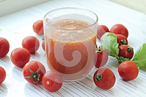 Glass of tomato juice on white background