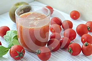 Glass of tomato juice on white background