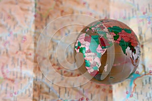 glass transparent crystal Globe against a navigational paper map background. globe and location map. planet Earth. empty copy