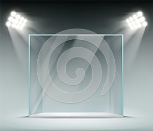 Glass transparent cube illuminated by spotlights. Showcase for the sale of goods